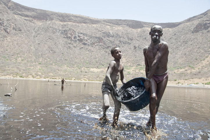 El Sod, Ethiopia - March 8th, 2012: Unidentified Borana boy helps his father to mine salt from the crater lake El Sod, Ethiopia on March 8, 2012.